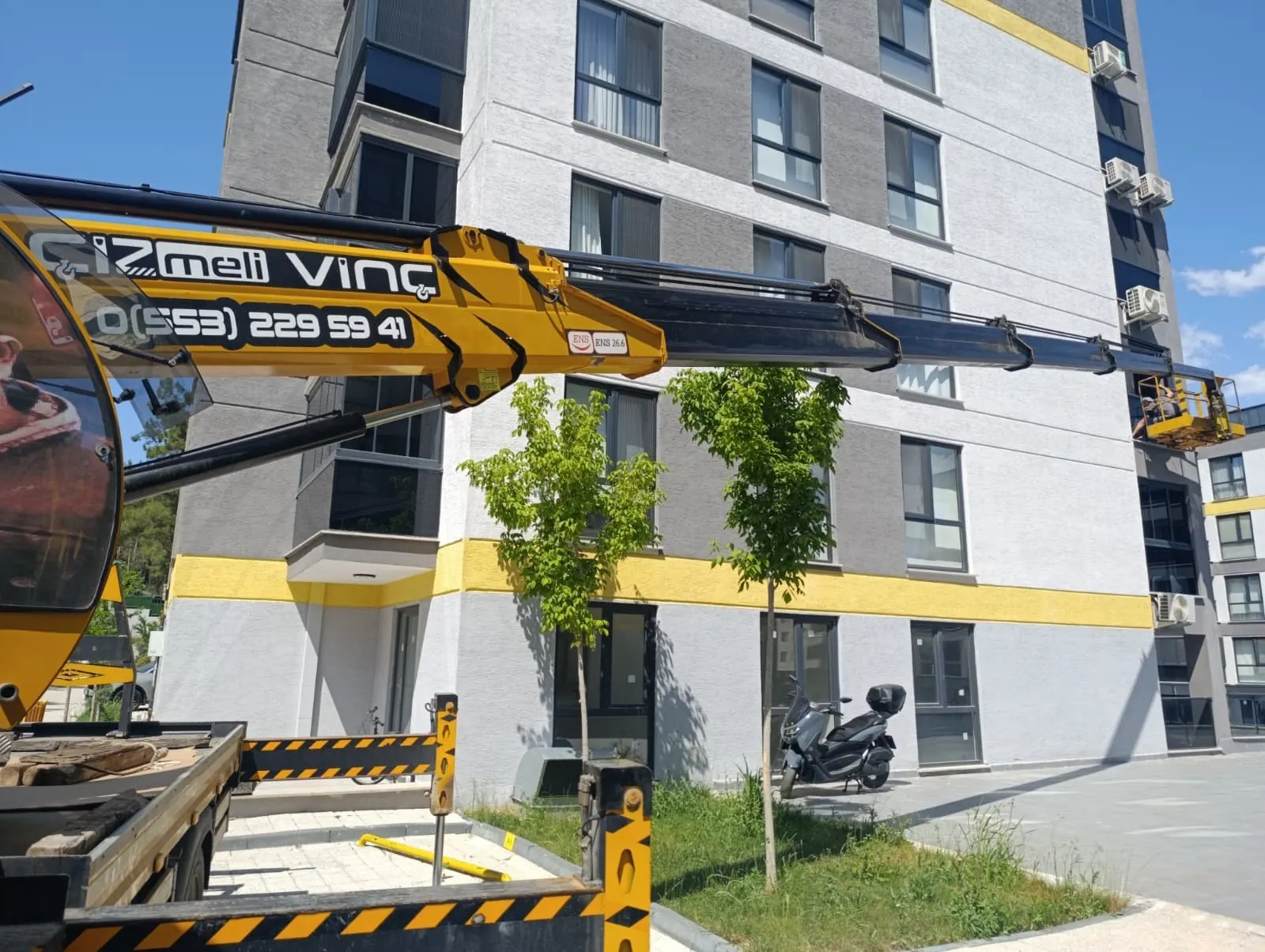 Sepetli vinçle bina cephesinde yüksekte tabela ve cephe montajı