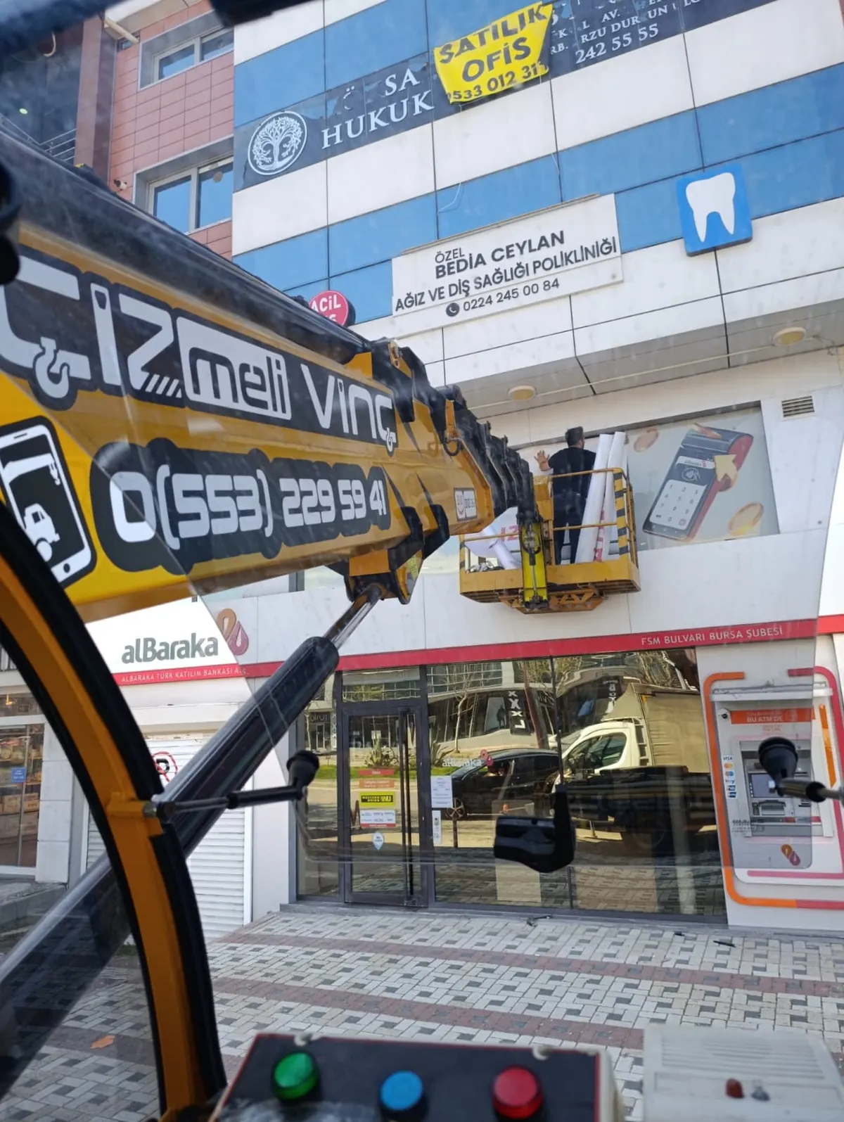 Sepetli vinçle bina cephesinde yüksekte tabela ve cephe montajı
